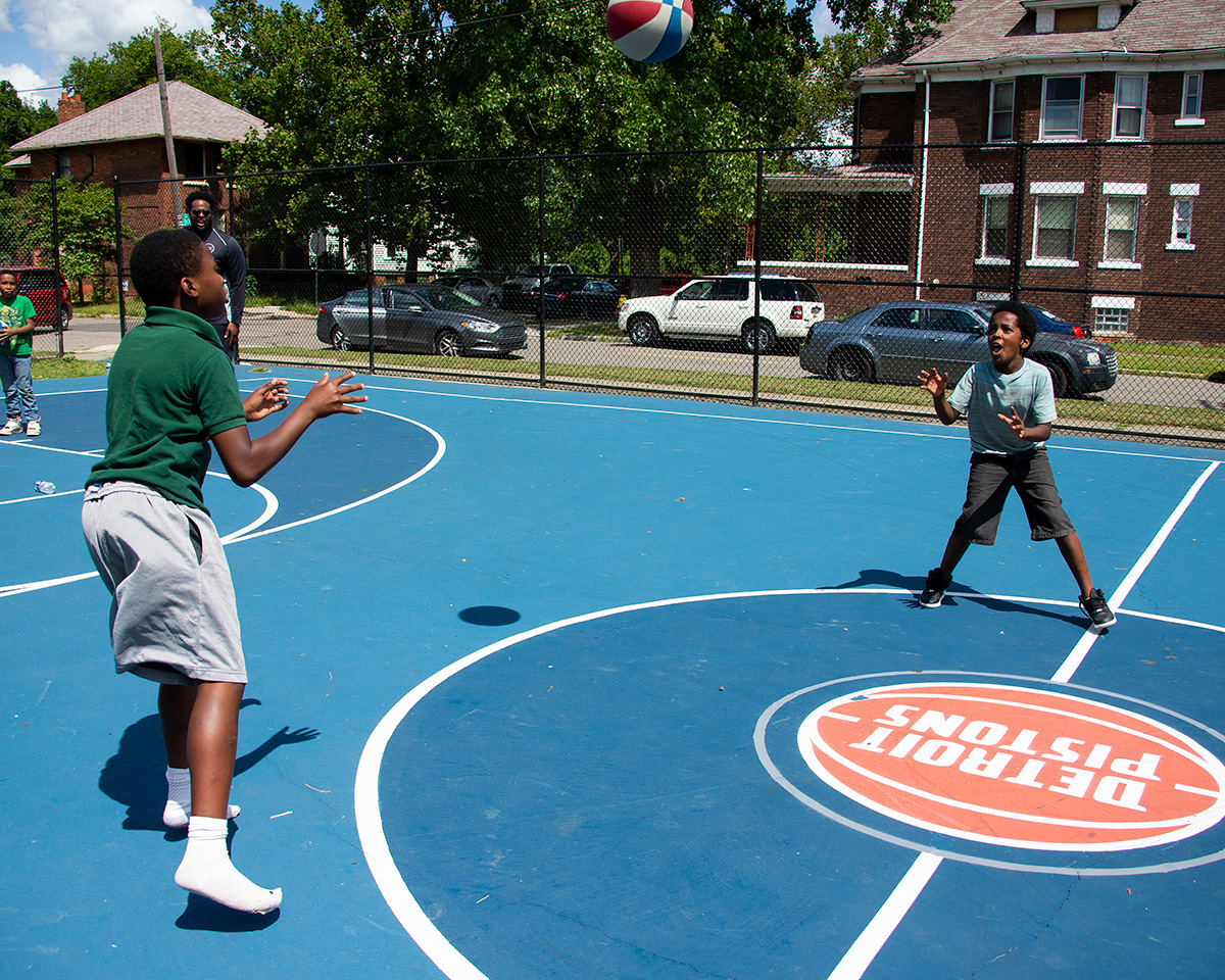 Children playing on a basketball court.